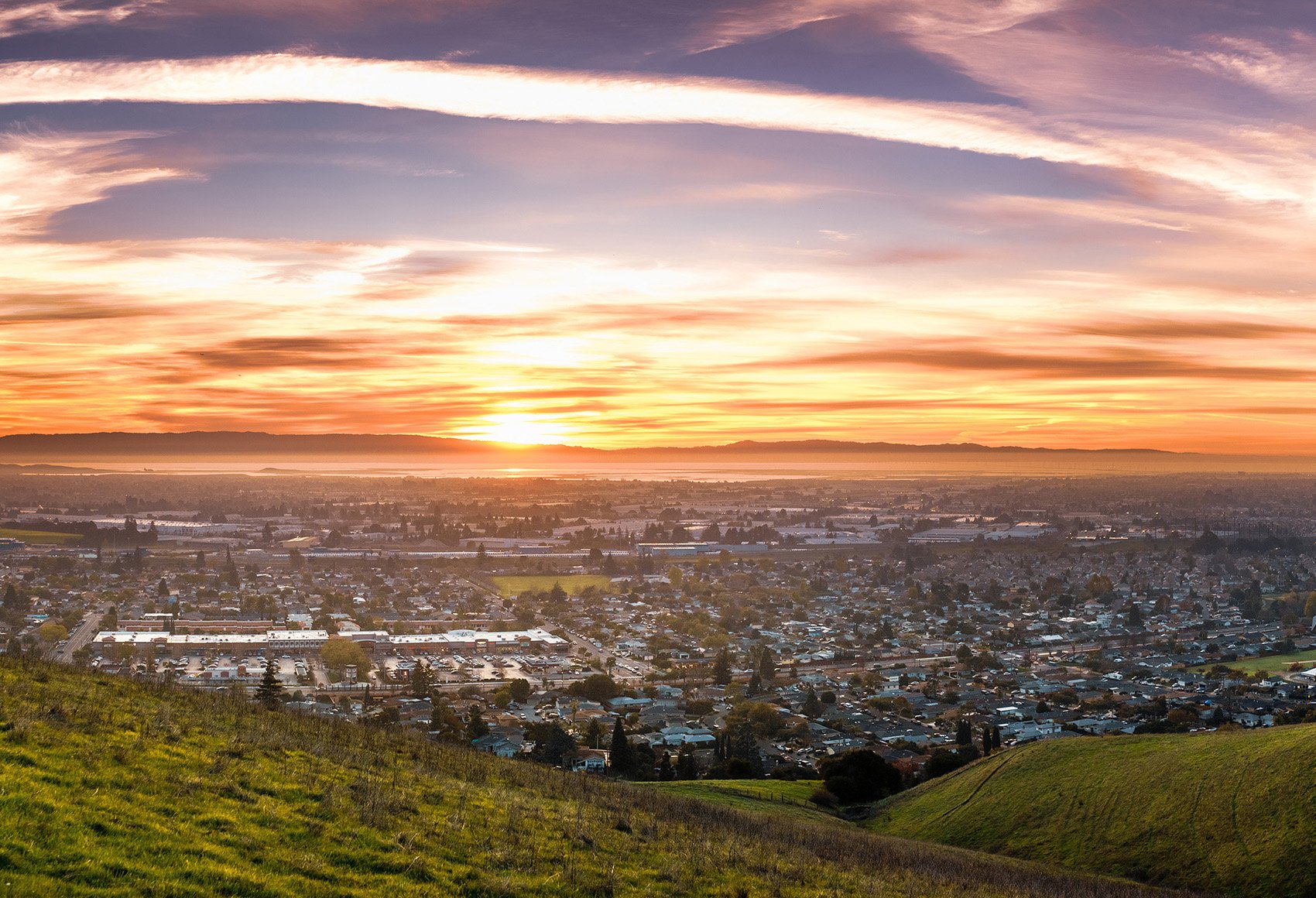 Wide shot of the city of Hayward in the Silicon Valley region of California, with a sunset in the horizon